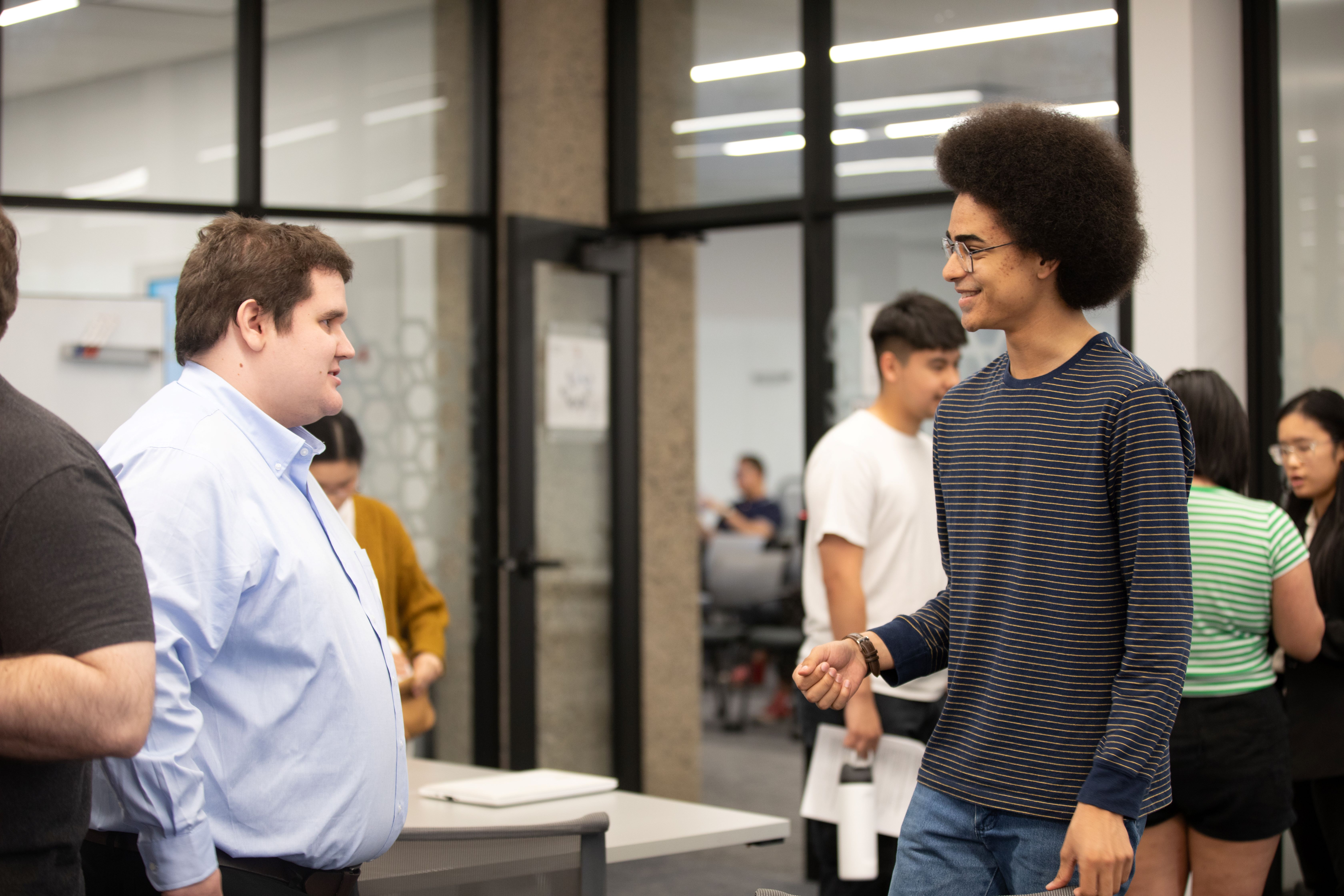 two undergraduate students smiling and talking with each other