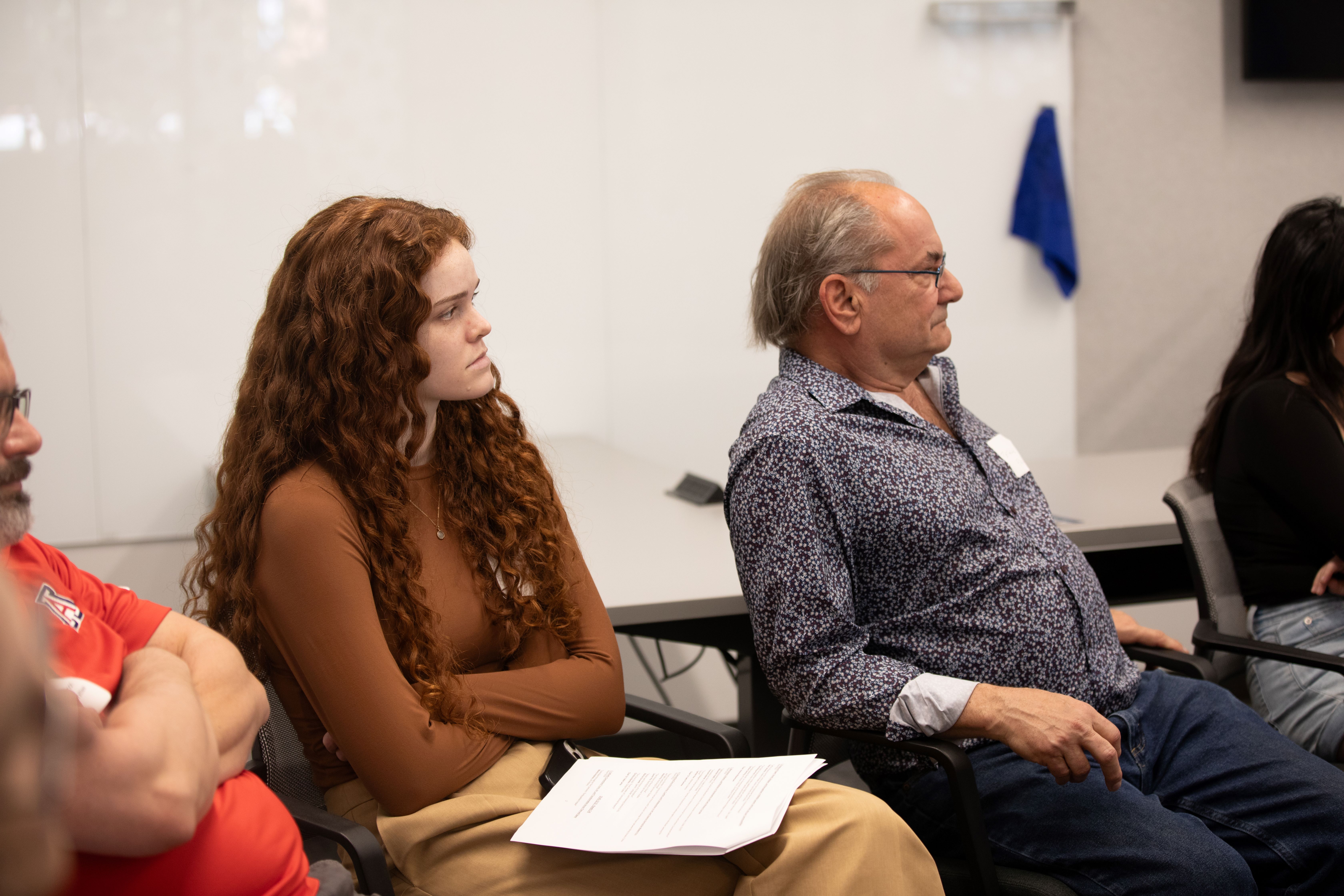 undergraduate student and professor watch presentation