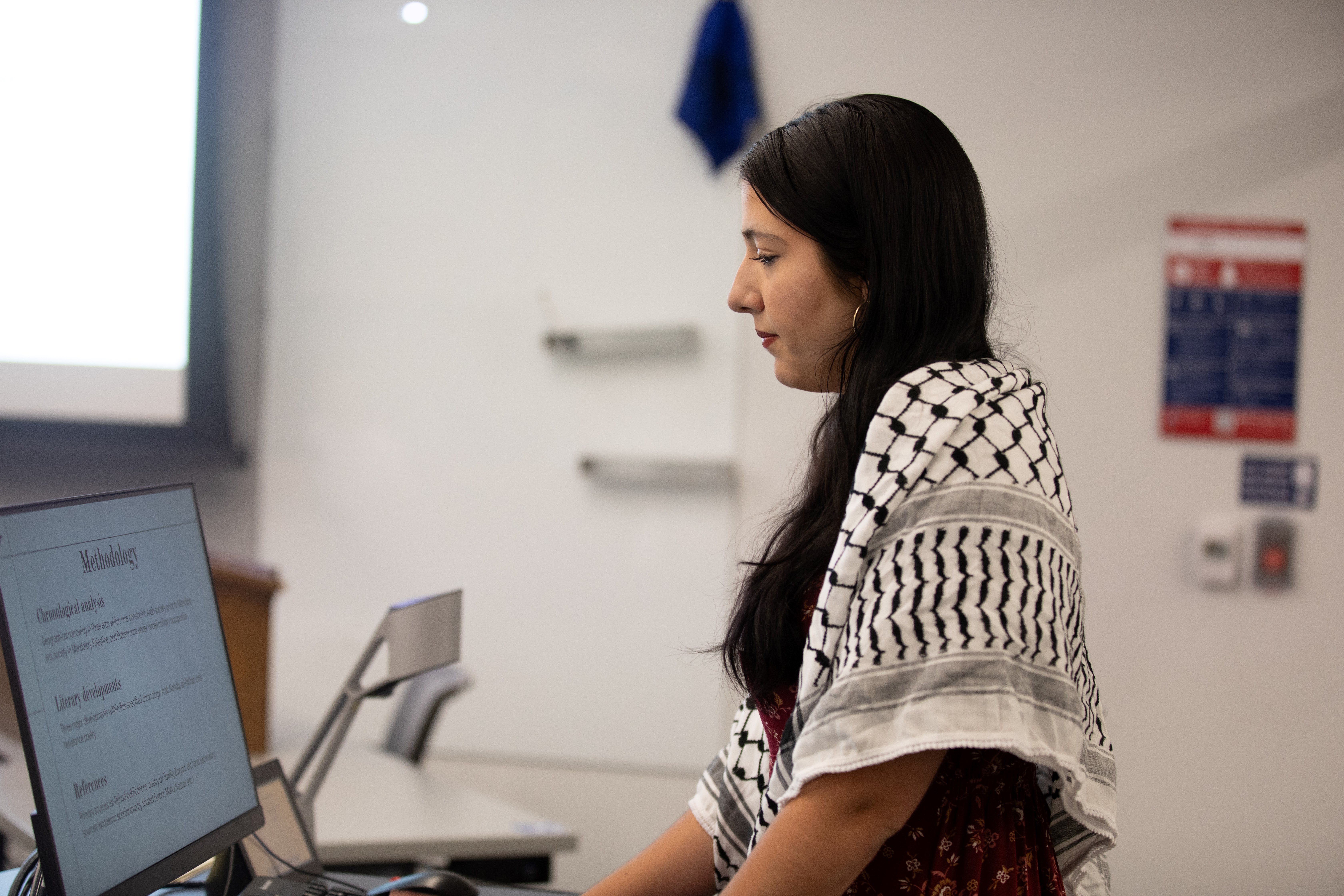 undergraduate student glances at a computer screen