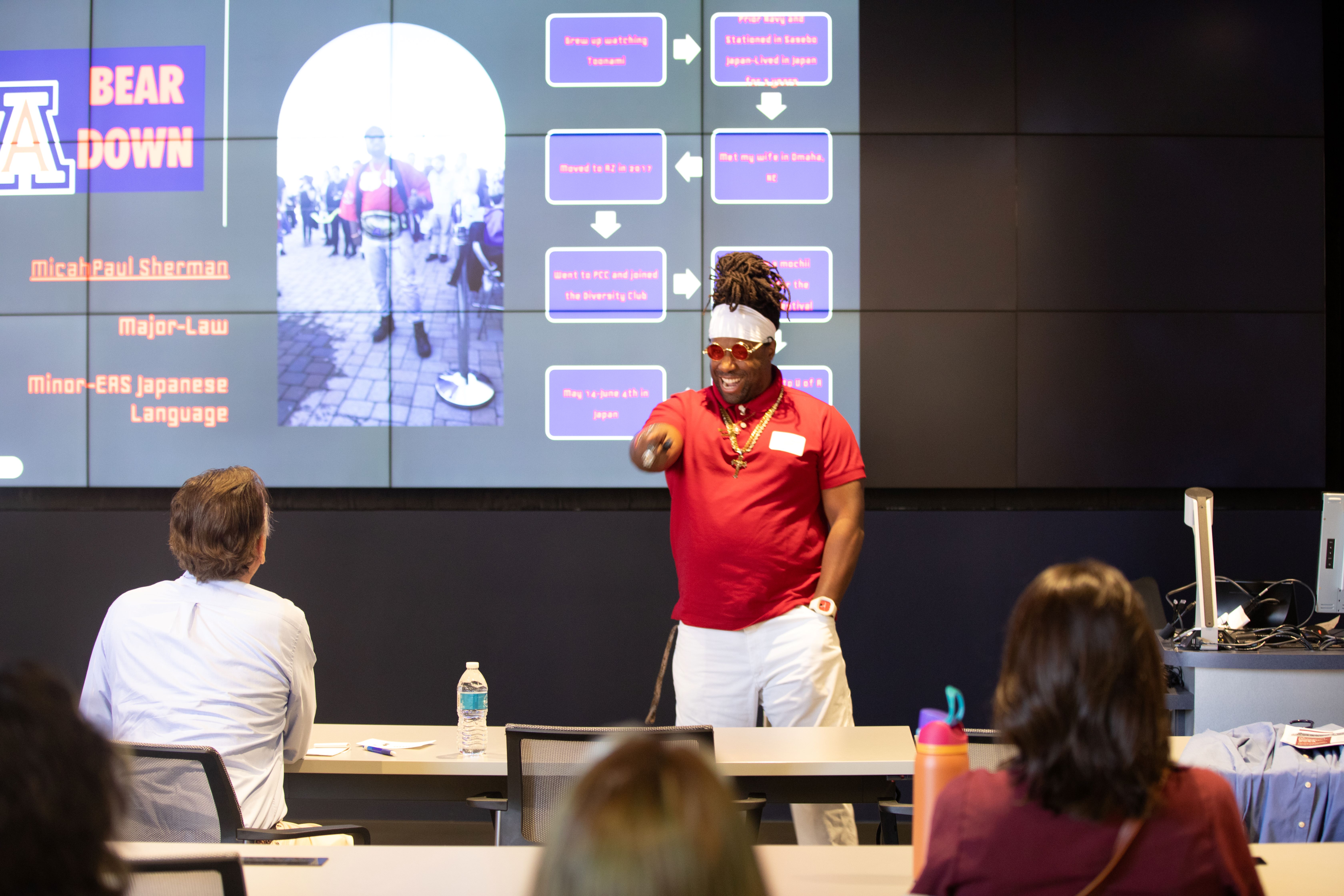 undergraduate student enthusiastically points as he presents his research