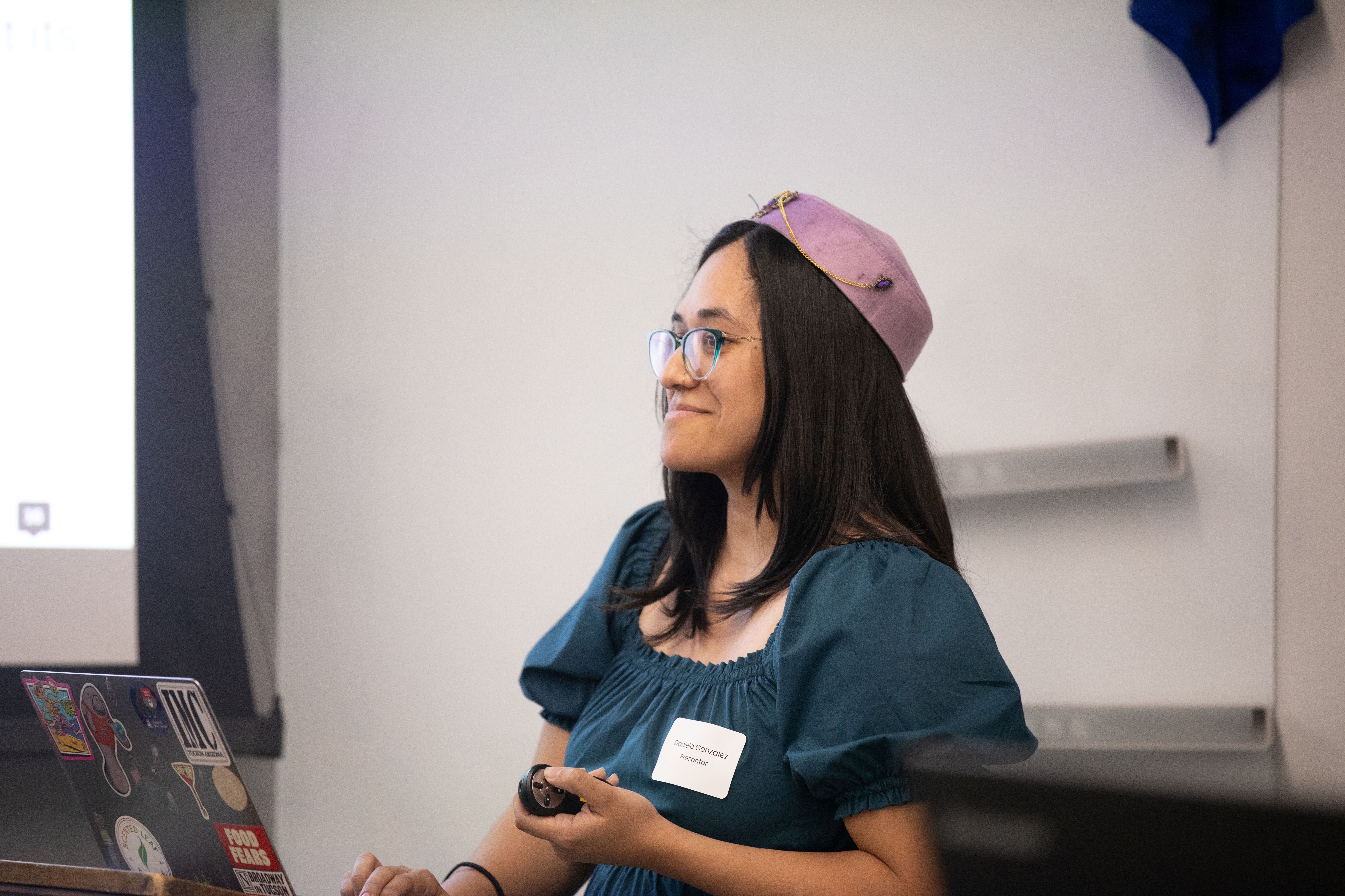 undergraduate student smiling as she presents her work