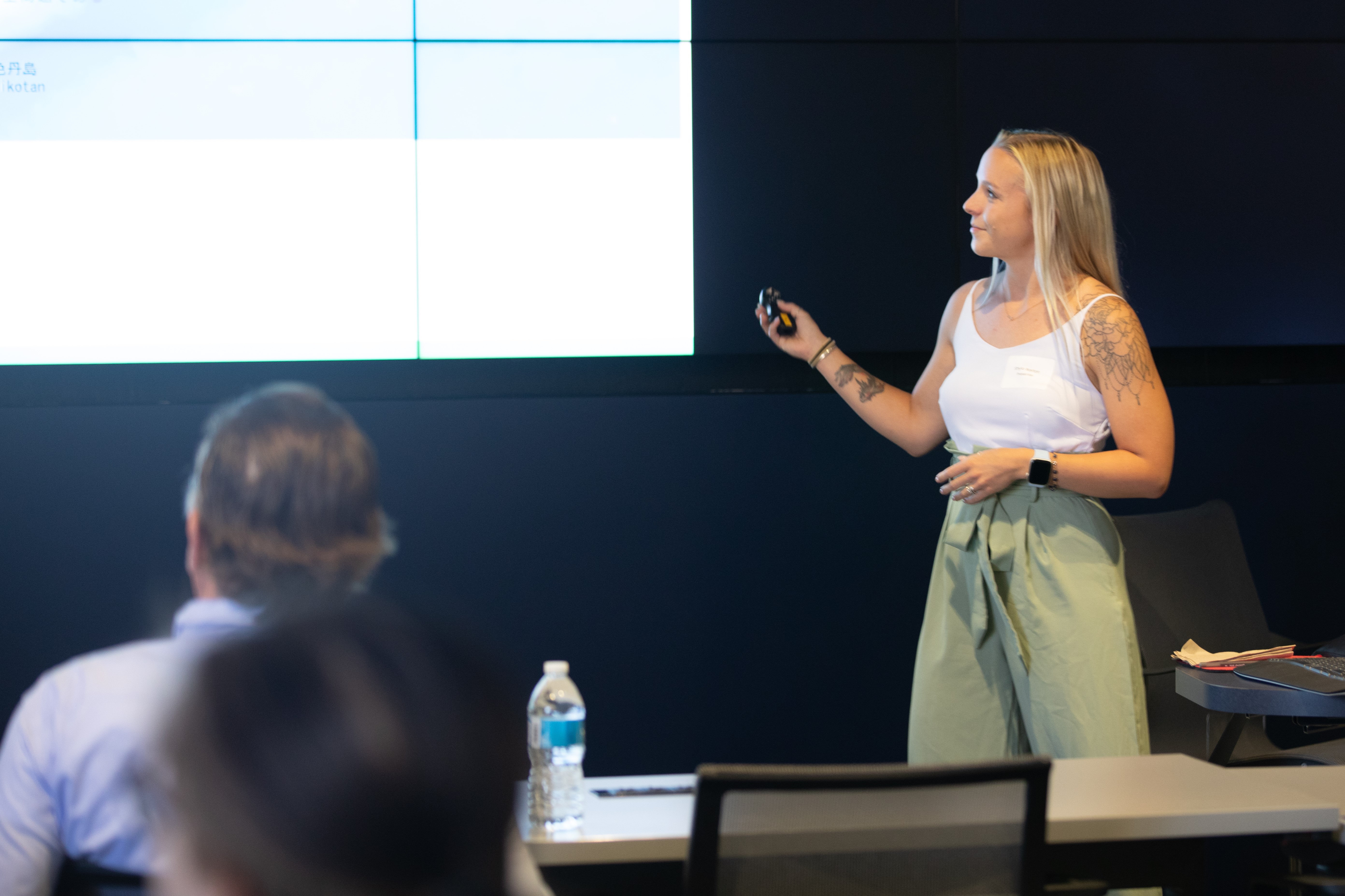 student looks toward her presentation smiling in front of an audience