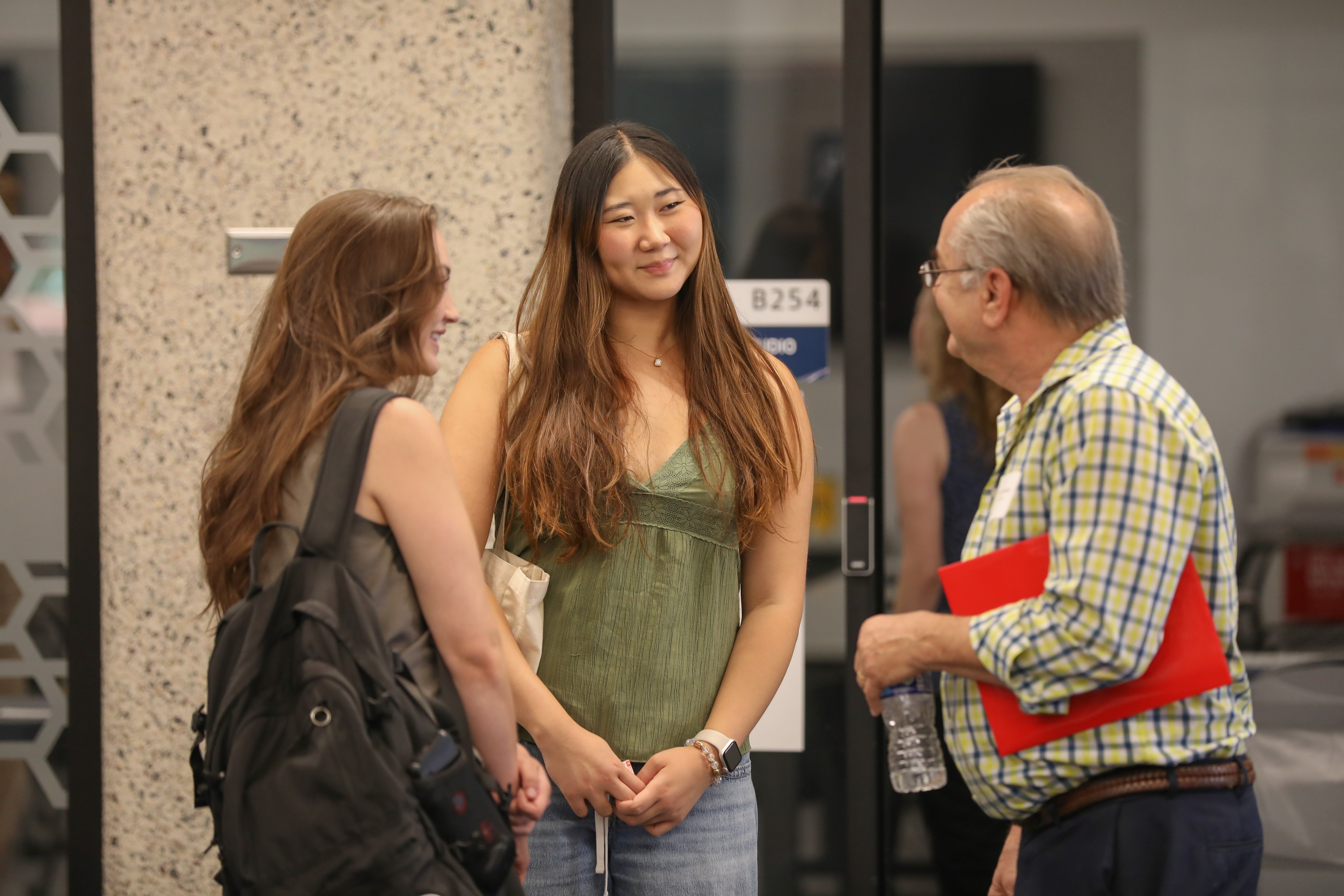 two students and faculty member talking