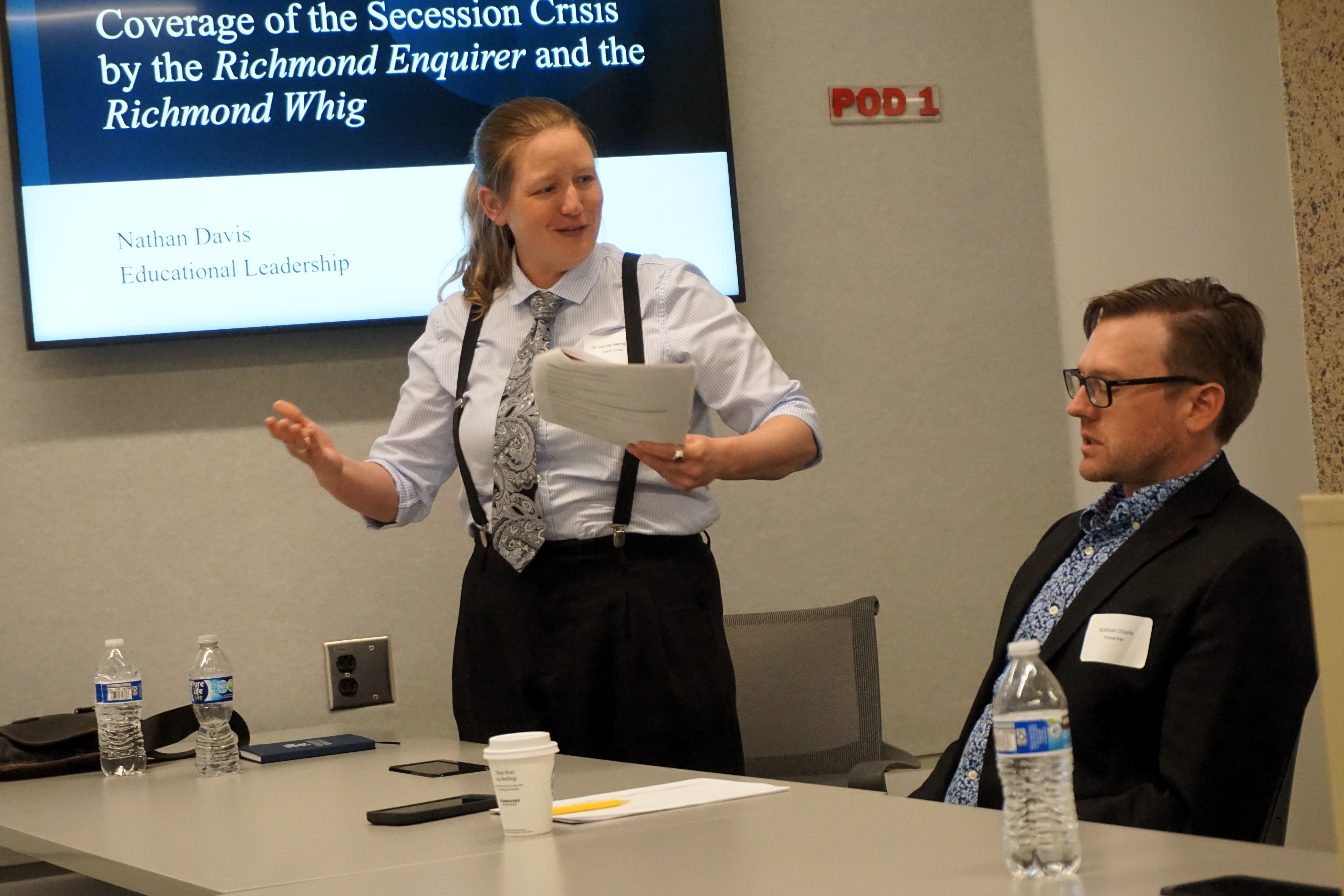 standing professor making comments to seated student